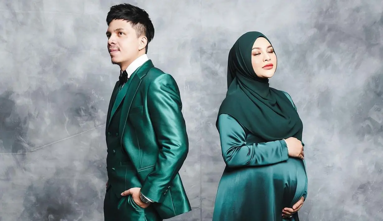Tetap kompak dengan outfit bernuansa hijau yang senada, kali ini Aurel tampil mengenakan long satin dress dengan hijab polos yang dipakai dengan secara basic. Sedangkan Atta mengenakan setelan tuksedo, yang sama-sama dari bahan satin dan berwarna hijau. Foto: Instagram.