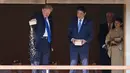 Presiden AS Donald Trump, disaksikan PM Jepang Shinzo Abe, menuangkan seluruh isi kotak makanan ikan ke kolam koi di Istana Akasaka, Tokyo, Senin (6/11). Insiden itu memicu kemarahan di kalangan pecinta ikan. (Toru Hanai/Pool Photo via AP)