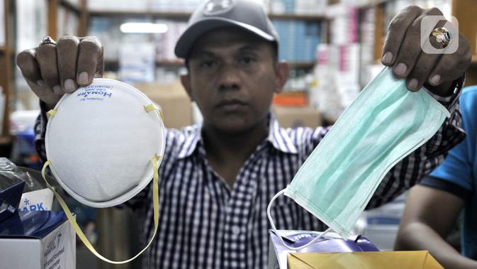 Pedagang menunjukkan masker jenis N-95 (kiri) dan biasa di toko alat kesehatan di Pasar Pramuka, Jakarta, Selasa (4/2/2020). Isu merebaknya wabah virus corona di Indonesia membuat penjualan masker di Pasar Pramuka meningkat pesat meski dalam sepekan harga melonjak tajam. (merdeka.com/Iqbal Nugroho)