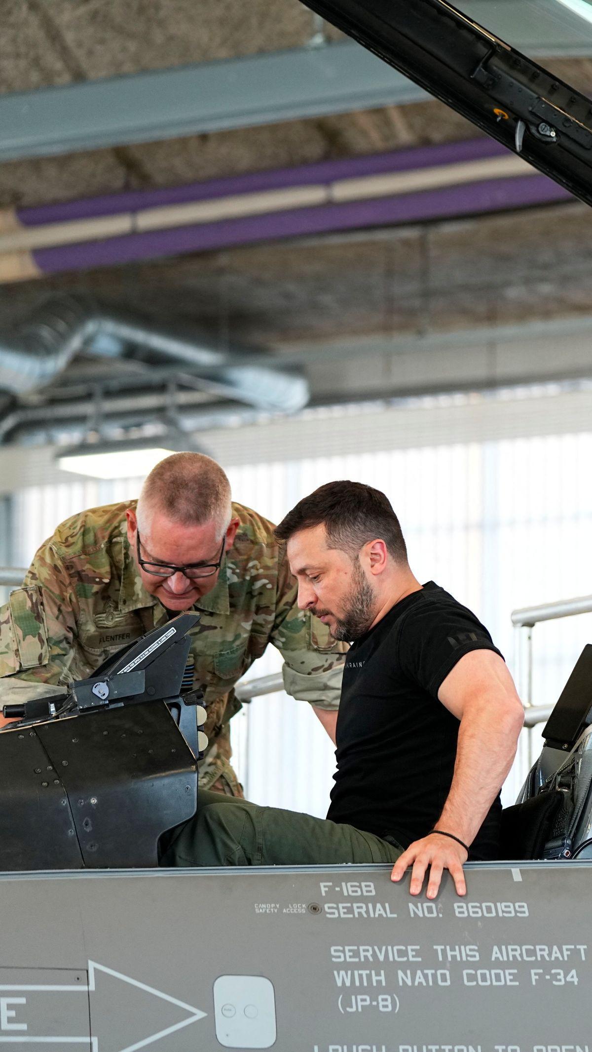 Saat mencoba duduk di  kokpit F-16 Denmark, Zelenskiyy tampak mendapat  penjelasan isi kokpit dari staf angkatan udara Denmark.