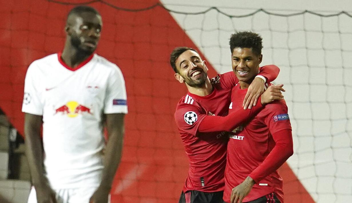 Penyerang Manchester United, Marcus Rashford, melakukan selebrasi bersama Bruno Fernandes usai mencetak gol ke gawang RB Leipzig pada laga Liga Champions di Stadion Old Trafford, Kamis (29/10/2020). MU menang dengan skor 5-0. (AP/Dave Thompson)