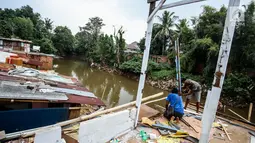 Warga mengambil bagian bangunan yang masih bisa digunakan di bantaran sungai Ciliwung, Bukit Duri, Jakarta, Rabu (5/7). Warga diharapkan sudah memindahkan barang-barangnya sebelum tiba waktu penertiban. (Liputan6.com/Faizal Fanani)