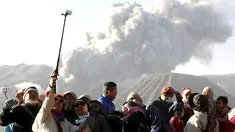 Wisatawan berfoto dengan latar belakang semburan abu vulkanik dari Gunung Bromo yang sedang erupsi di Ngadisari, Probolinggo, Jawa Timur, Rabu (6/1/2016). (REUTERS/Darren Whiteside)