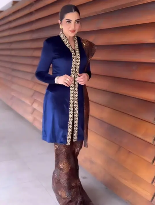 Di momen kelulusan Azriel, Ashanty tampil super cantik mengenakan kebaya velvet biru tua dengan sentuhan ujung bernuansa emas yang menambah nuansa mewah, serta padu padan batik cokelat gelap sebagai rok dan selendang. [Foto: Instagram/ashanty_ash]