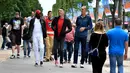 Sejumlah pria tertinggi di dunia berjalan di tengah keramaian di Champs-Elysees Avenue, Paris, 1 Juni 2018. Belasan pria tertinggi di dunia bertemu pada akhir pekan di ibu kota Prancis. (AFP/GERARD JULIEN)