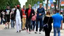 Sejumlah pria tertinggi di dunia berjalan di tengah keramaian di Champs-Elysees Avenue, Paris, 1 Juni 2018. Belasan pria tertinggi di dunia bertemu pada akhir pekan di ibu kota Prancis. (AFP/GERARD JULIEN)