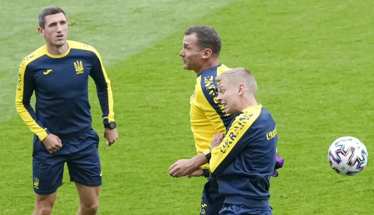 Pemain Ukraina Oleksandr Zinchenko (kanan) melompat untuk sundulan dengan pelatih kepala Andriy Shevchenko saat sesi latihan jelang melawan Austria pada pertandingan Grup C Euro 2020 di Stadion Arcul de Triumf, Bucharest, Rumania, Minggu (20/6/2021). (AP Photo/Vadim Ghirda)