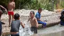 Anak-anak Palestina menikmati waktu bermain di sebuah mata air alami di tengah gelombang panas di Kota Jericho, Tepi Barat, (18/5/2020). (Xinhua/Luay Sababa)