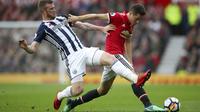 Aksi pemain West Bromwich, Chris Brunt (kiri) menutup ruang gerak pemain Manchester United, Ander Herrera pada lanjutan Premier League di Old Trafford, Manchester,(15/4/2018). Manchester United kalah 0-1. (Nick Potts/PA via AP)
