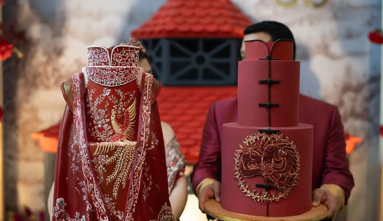 Wanita berusia 29 tahun itu mengenakan pakaian nuansa merah, begitu juga calon suaminya yang juga tampil gagah dengan mengenakan setelan jas merah. [Instagram/tinatoon101]