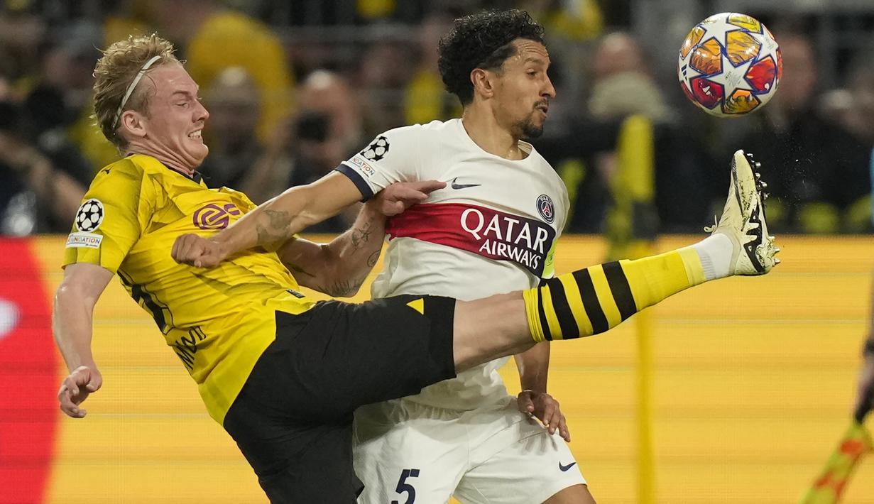 Bek PSG, Marquinhos (kanan) berebut bola dengan gelandang Borussia Dortmund, Julian Brandt pada laga leg pertama semifinal Liga Champions 2023/2024 di Signal Iduna Park Stadium, Dortmund, Rabu (1/5/2024). (AP Photo/Matthias Schrader)
