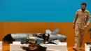 Perwira militer melewati puing-puing rudal yang digunakan dalam serangan kilang minyak Aramco pada konferensi pers di Riyadh, Arab Saudi, Rabu (18/9/2019). Amerika Serikat bersikukuh dengan tuduhan bahwa Iran berada di balik serangan tersebut. (AP Photo/Amr Nabil)