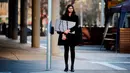 Seorang wanita membawa monitor komputer untuk memungkinkannya bekerja dari rumah saat dia berdiri di sebuah jalan di Canberra, Australia, Kamis (12/8/2021). Canberra belum pernah mengalami lockdown sejak awal pandemi COVID-19. (Rohan Thomson/AFP)