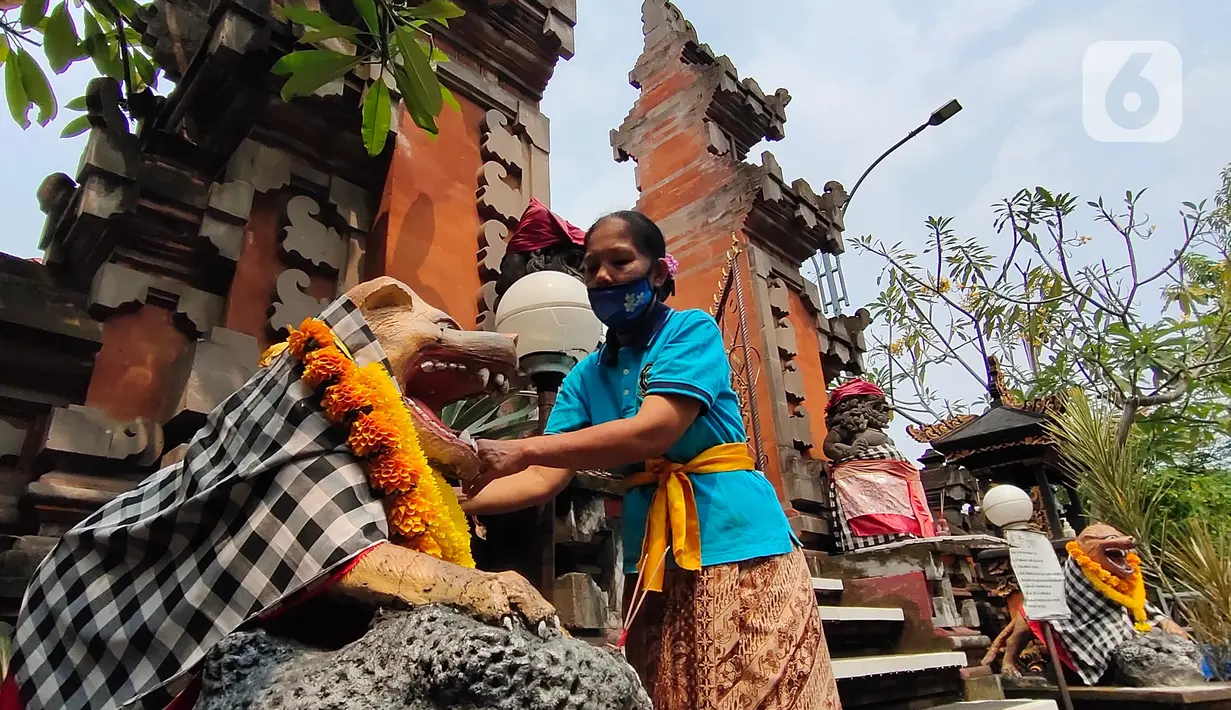 Umat Hindu memasang hiasan di Pura Kerta Jaya, Kota Tangerang, Banten, Selasa (15/9/2020). Persiapan tersebut dilakukan jelang Hari Raya Galungan yang jatuh pada 16 September 2020. (Liputan6.com/Angga Yuniar)
