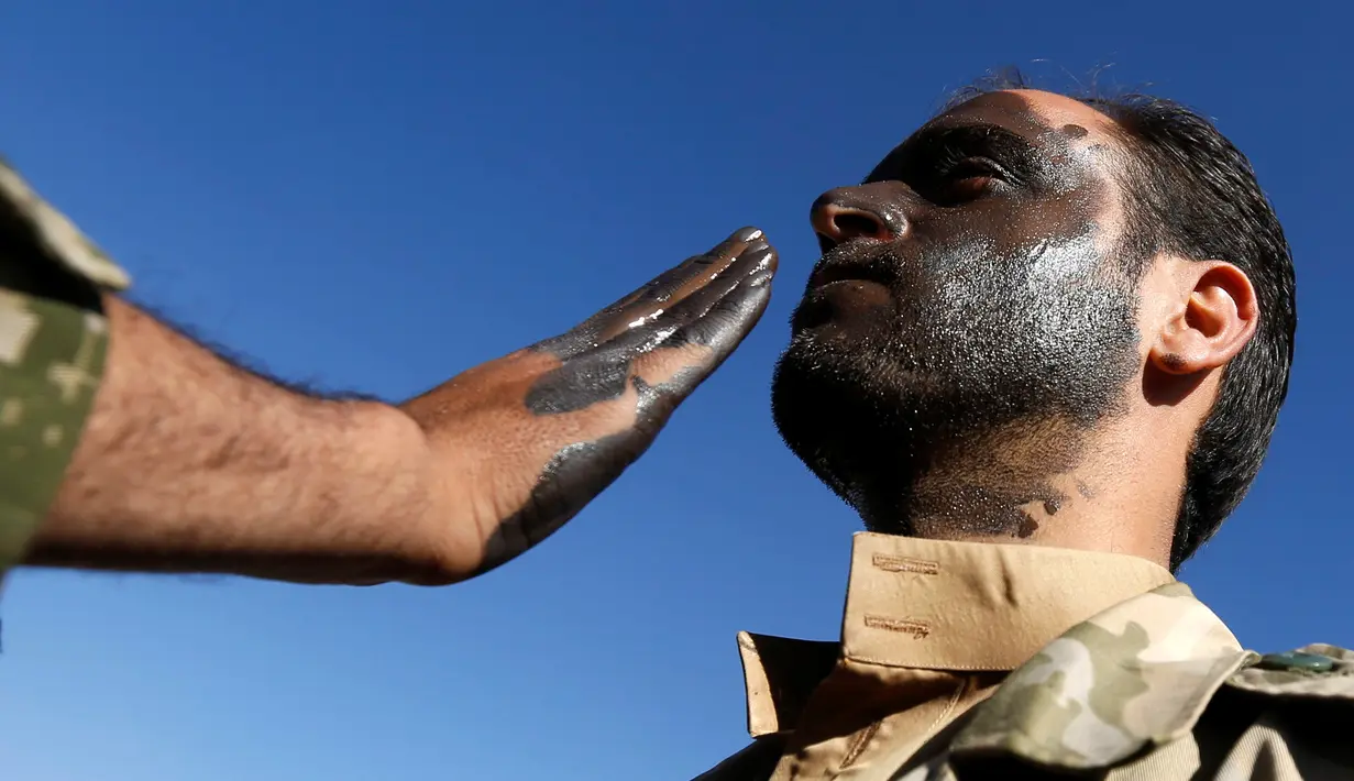 Anggota Houthi baru diwarnai wajahnya saat akan menuju pertempuran melawan pasukan pemerintah Yaman di Sanaa, Selasa (3/1). (REUTERS / Khaled Abdullah)