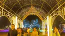 Para pengunjung sedang menikmati lorong dengan warna-warni lampu yang bertempat di Charming Chiang Mai Flower Festival pada Kamis (11/12/2025). (Bola.com/Bagaskara Lazuardi)