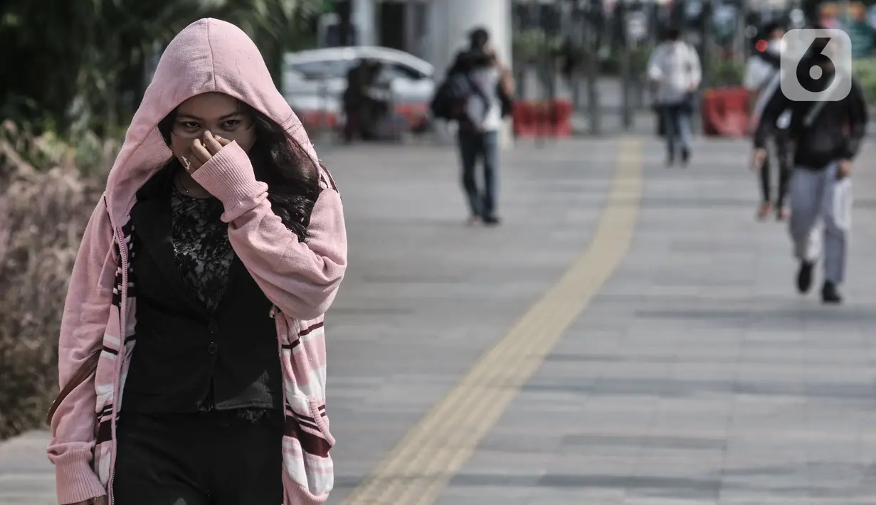 Warga merapikan masker saat beraktivitas di kawasan Sudirman, Jakarta, Selasa (1/9/2020). Jika terjadi lonjakan kasus positif Covid-19 secara signifikan maka secara otomatis akan dilanjutkan mulai 11-24 September mendatang. (merdeka.com/Iqbal S. Nugroho) (merdeka.com/Iqbal S. Nugroho)