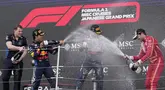 Pembalap Red Bull Max Verstappen (kedua kanan) dan Sergio Perez (kedua kiri) merayakan kemenangan timnya bersama pembalap Ferrari Carlos Sainz usai GP Jepang Formula 1 2024 di Sirkuit Suzuka, Jepang, Sabtu (04/07/2024).  (Foto AP/Hiro Komae)