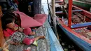 Seorang anak duduk di atas kapal pasca penggusuran permukiman Pasar Ikan, Jakarta, Selasa (13/4/2016). Warga Pasar Ikan mengaku belum mendapat rumah susun sewa yang telah dijanjikan oleh Pemprov DKI Jakarta. (Liputan6.com/Faizal Fanani)