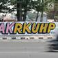 Mural bertulis '#TolakRKUHP' terpampang pada dinding di Jalan Pemuda, Rawamangun, Jakarta, Selasa (1/10/2019). Mural tersebut respons dari seniman Jakarta terhadap RUU KUHP yang dinilai mencederai tatanan demokrasi. (merdeka.com/Iqbal Nugroho)