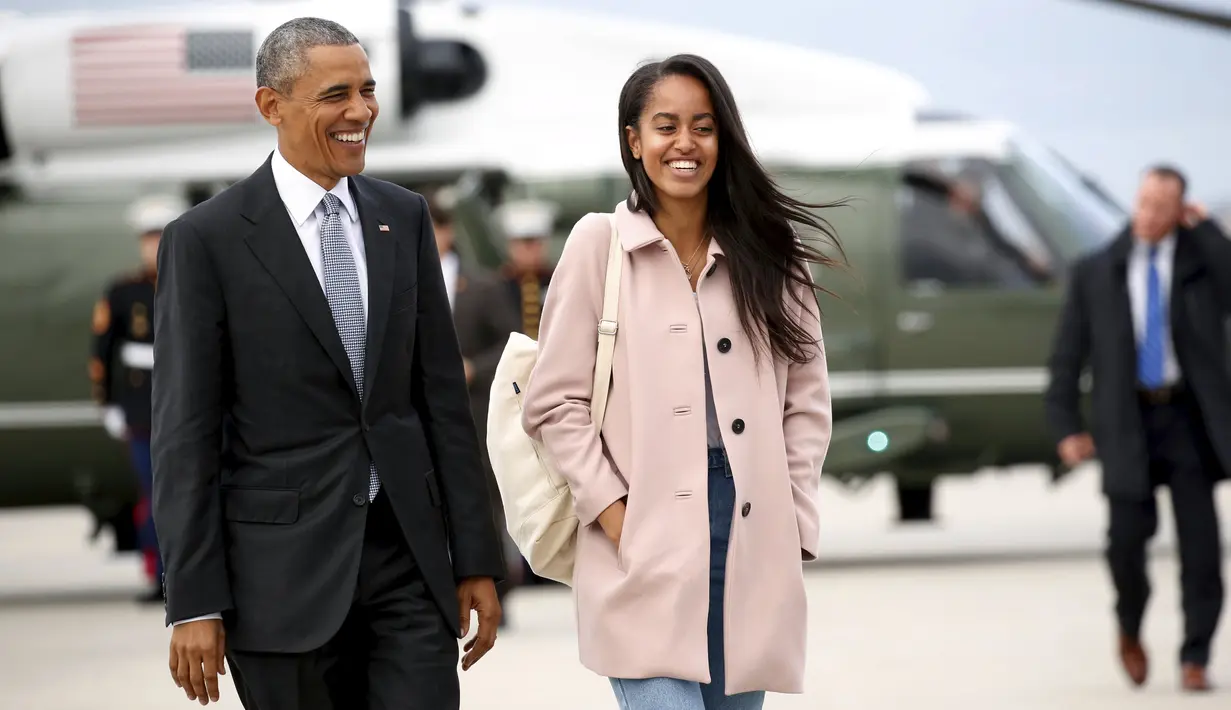 Presiden AS, Barrack Obama dan putrinya, Malia, tertawa saat berjalan menunju pesawat Air Force One dari Bandara O'Hare, Chicago, Kamis (7/4/2016). (REUTERS/Kevin Lamarque)