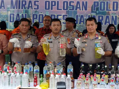 Kapolda Metro Jaya Irjen Pol Idham Azis (tengah) dan jajaraannya menunjukkan barang bukti saat rilis hasil operasi miras di Polda Metro Jaya, Jakarta, Jumat (20/4). Jajaran Polda Metro Jaya berhasil menyita 39.834 botol miras. (Liputan6.com/Arya Manggala)