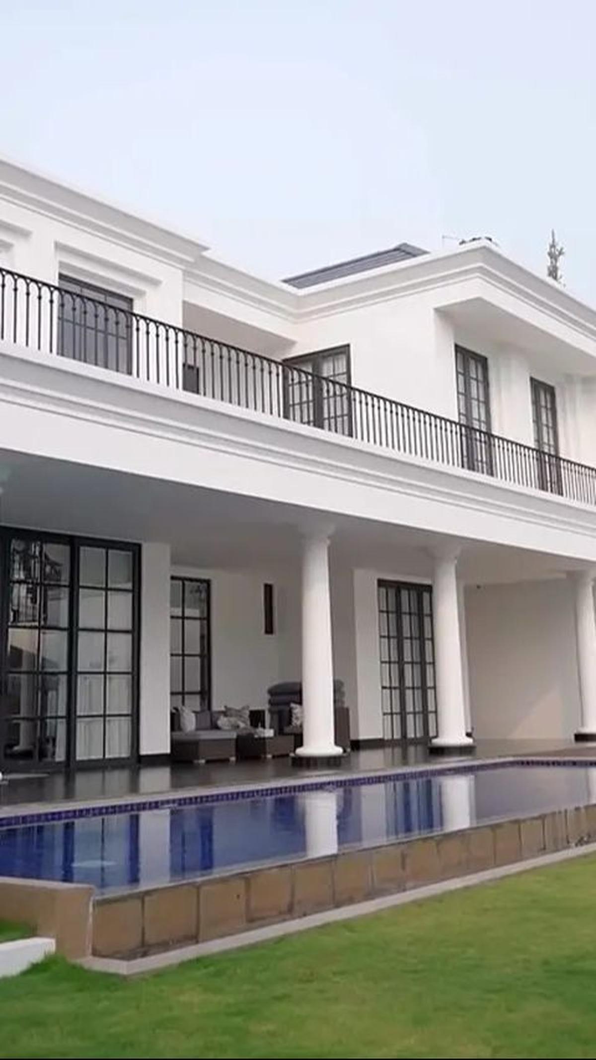 Kolam renang besar disorot, memberikan pemandangan hijau nan asri.