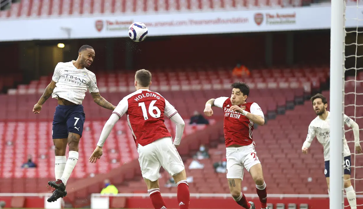 Penyerang Manchester City, Raheem Sterling (kiri) mencetak gol pembuka untuk timnya ke gawang Arsenal pada lanjutan Liga Inggris di Emirates Stadium, Minggu (21/2/2021). Manchester City kian mengokohkan posisinya di puncak klasemen setelah menang 1-0 di kandang Arsenal. (Julian Finney/Pool via AP)