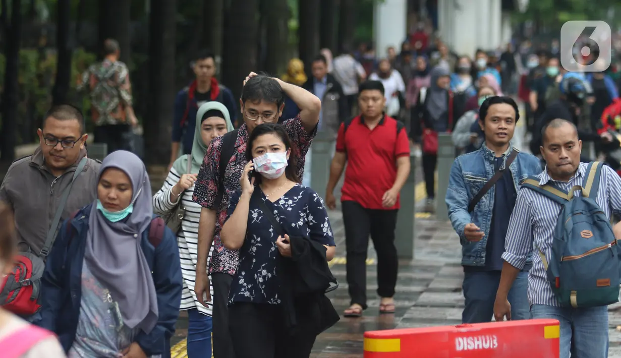 Pekerja berjalan kaki saat jam pulang di kawasan Sudirman, Jakarta, Jumat (7/2/2020). BPJS Ketenagakerjaan yang kini bernama BP Jamsostek menargetkan sekitar 23,5 juta tenaga kerja baru masuk dalam daftar kepesertaan pada 2020. (Liputan6.com/Angga Yuniar)