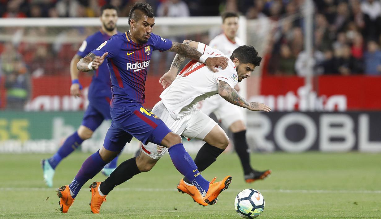<p>Pemain Barcelona, Paulinho Bezerra (kiri) mencoba melewati adangan pemain Sevilla, Banega pada laga La Liga Santander di Sanchez Pizjuan stadium, (31/3/2018). Barcelona bermain imbang 2-2 dengan Sevilla. (AP/Miguel Morenatti)</p>