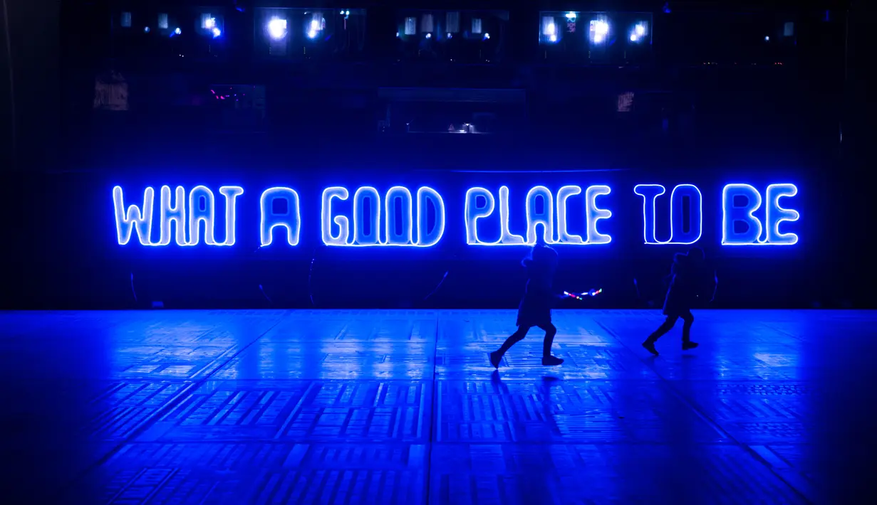 Anak-anak berlari di depan instalasi cahaya-seni yang berjudul 'What A Good Place To Be' karya Debi Keable sebagai bagian dari dalam Festival Seni Visual Lightpool di situs bekas kantor polisi, Blackpool, Inggris (26/10). (AFP Photo/Oli Scarff)