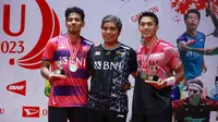 Tunggal putra Indonesia, Jonatan Christie (kanan) berpose dengan medali dan trofi juara di atas podium bersama lawannya sesama wakil Indonesia, Chico Aura Dwi Wardoyo dan peatih Irwansyah setelah pertandingan final Indonesia Masters 2023 di Istora Senayan, Jakarta, Minggu (29/1/2023). Jonatan Christie menang dengan dua game langsung 21-15, 21-13. (Bola.com/M Iqbal Ichsan)