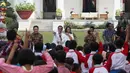 Presiden Joko Widodo dan Ibu Negara Iriana menunjuk seorang anak pada acara bermain, berdendang dan berimajinasi bersama anak-anak dari beberapa sekolah di halaman belakang Istana Merdeka, Jakarta, Jumat (20/7). (Liputan6.com/Angga Yuniar)