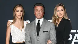 Sylvester Stallone (tengah) berpose dengan dua putrinya, Sistine Stallone (kiri) dan Sophia Stallone saat menghadiri Saint Laurent Fall Collection di Los Angeles, California, Rabu (10/2/2016). (Larry Busacca/Getty Images for SAINT LAURENT)