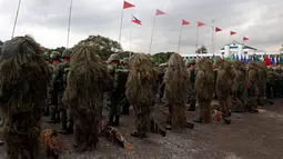 Barisan tentara penembak jitu yang mengenakan pakaian kamuflase saat upacara pergantian Kepala Angkatan Bersenjata di kamp militer di Kota Quezon, Manila, Filipina (7/12). Tentara ini melakukan penyamaran dari kejauhan. (Reuters/Erik De Castro)