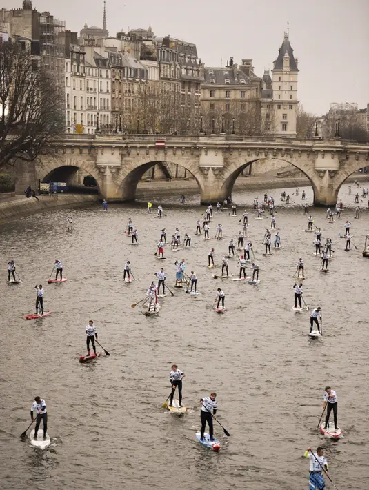 Peserta mendayung melewati aliran sunga- sungai selama perlombaan dayung dan perahu di Sungai Seine di Paris, Perancis, Minggu, (2/12). Peserta akan mendayung sejauh 10 km. (AFP)