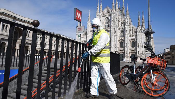Pekerja membersihkan permukaan jalan di Piazza del Duomo, Milan, 31 Maret 2020. Pandemi COVID-19 terus menyebar di Italia pada Selasa (31/3), menambah total jumlah terinfeksi, kematian dan pulih menjadi 105.792, menurut data terbaru Departemen Perlindungan Sipil Italia. (Xinhua/Daniele Mascolo)