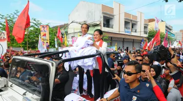 Capres 01 Joko Widodo di dampingi Istri Iriana Joko Widodo saat kampanye terbuka di Banyumas, Jawa Tengah, Kamis (4/4). Dalam kampanye tersebut Jokowi mengajak para pendukung untuk memerangi hoax dan memenangkan pasangan no urut 01 Jokowi-ma'ruf di banyumas.(Liputan6.com/Angga Yuniar)