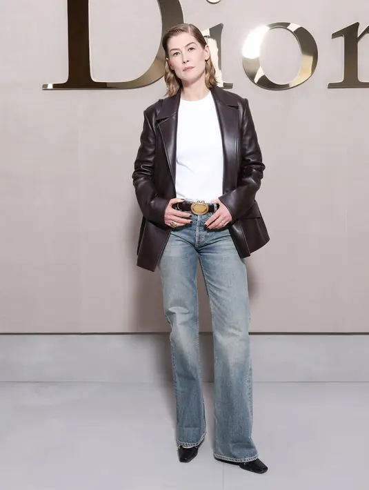 Rosamund Pike tampil boyish dengan t-shirt berlapis blazer kulit dan celana jeans. Lengkap dengan ikat pinggang Dior [Dior]