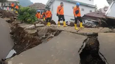 Petugas melintas di jalan yang rusak  pascagempa bumi magnitudo 5,6 di Kampung Cisarua, Desa Sarampad, Kabupaten Cianjur, Jawa Barat, Rabu (23/11/2022). Berdasarkan data BNPB sebanyak 58.362 warga mengungsi akibat gempa bumi di Kabupaten Cianjur tersebut. (merdeka.com/Arie Basuki)