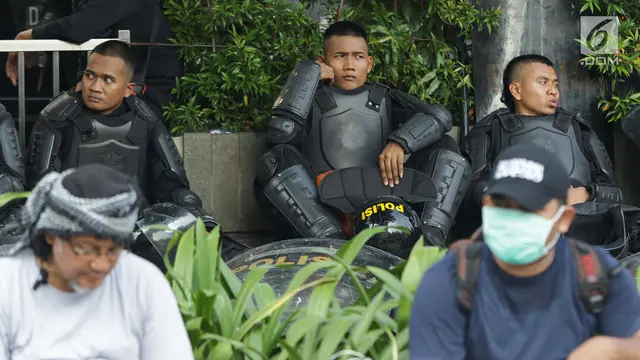 Potret Ekspresi Polisi Saat Menjaga Aksi Unjuk Rasa