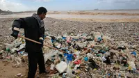 Pekerja membersihkan tumpukan sampah yang tersapu ke darat saat badai melanda kota pantai Zouq Mosbeh di utara Beirut, Lebanon, 22 Januari 2018. Hampir segala limbah termasuk plastik hingga pembalut wanita menumpuk di pantai itu. (AP/Hussein Malla)