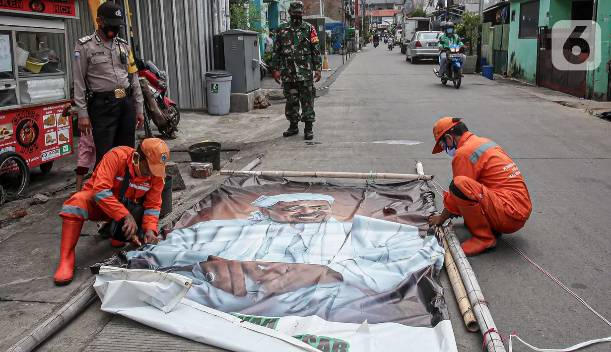 Petugas PPSU didampingi TNI dan Polri mencopot baliho Rizieq Shihab di Kawasan Kramat Pulo Dalam Senen, Jakarta, Rabu (25/11/2020). Pihak kelurahan, TNI dan Polri terus berupaya menurunkan baliho dan spanduk yang tidak berizin, termasuk salah satunya baliho Rizieq Shihab (Liputan6.com/Faizal Fanani)