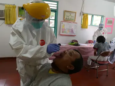 Tim medis Puskesmas Kecamatan Pulogadung melakukan swab tes (usap tes) pedagang pasar Burung Cipinang Kebembem, Jakarta, Jumat (19/6/2020). Sebanyak 82 orang yang mengikuti pemeriksaan swab tes dilakukan untuk memutus rantai penularan virus Corona (COVID-19). (merdeka.com/Imam Buhori)