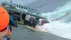 Penumpang berpegangan pada besi kapal saat KM Lestari Maju tenggelam di lepas pantai Pulau Selayar, Provinsi Sulawesi Selatan, Selasa (3/7). KM Lestari Maju tenggelam di Perairan Selayar sekitar pukul 14.30 WIT. (BNPB/AFP)