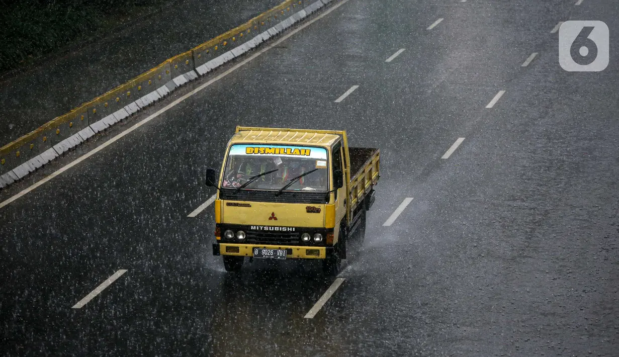 Sebuah truk melintas di tengah hujan lebat di kawasan Jalan Sudirman, Jakarta, Selasa (29/6/2021). BMKG mengungkapkan wilayah Jakarta dan sekitarnya masih dilanda hujan dan hawa dingin di musim kemarau. (Liputan6.com/Faizal Fanani)