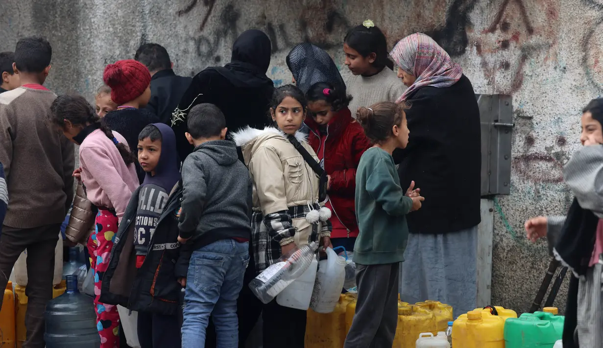 Para wanita dan anak-anak mengantre untuk mendapatkan air di Rafah, wilayah selatan Jalur Gaza pada 9 Februari 2024. (Mohammed ABED/AFP)