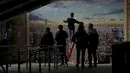 Orang-orang berhenti untuk menyaksikan seniman jalanan Australia James Cochran, juga dikenal sebagai Jimmy C, memberikan sentuhan akhir pada mural lanskap kota London-nya di dinding Network Rail oleh Blackfriars Station, di London (5/10/2020). (AP Photo/Matt Dunham)