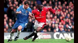 Striker Manchester United, Andy Cole (kanan) berebut bola dengan bek Chelsea, Steve Clarke pada laga Liga Inggris 1997/1998 di Stamford Bridge Stadium, London (28/2/1998). Andy Cole total mencetak 93 gol dari 195 laga bagi MU di Premier League sejak didatangkan dari  Newcastle United pada tengah musim 1994/1995 hingga tengah musim 2001/2002. Pada tengah musim 2001/2002 ia memutuskan hijrah ke Blackburn Rovers. (AFP/PA/Adam Butler)