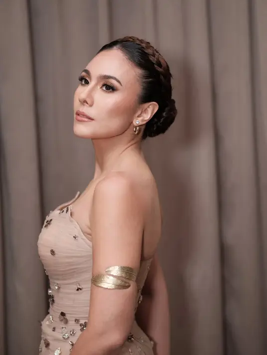 Wulan Guritno pulas wajahnya dengan makeup soft glam bernuansa gold. Sementara rambutnya ditata braided updo yang rapi [@wulanguritno]